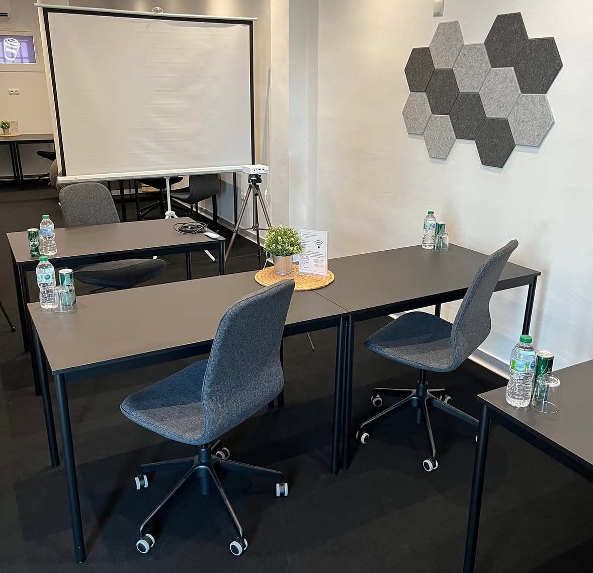 Flexible Einzeltische im Seminarraum, aufgebaut vor Leinwand und Beamer