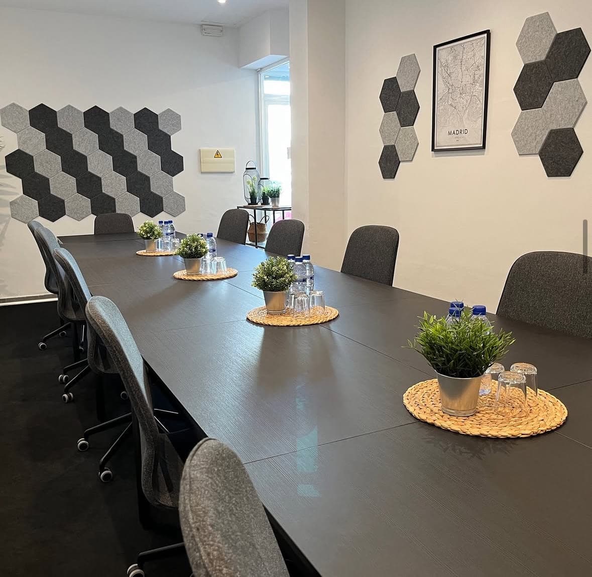 Seminarraum als lange Konferenztafel aufgebaut, mit Wasser und Gläsern eingedeckt