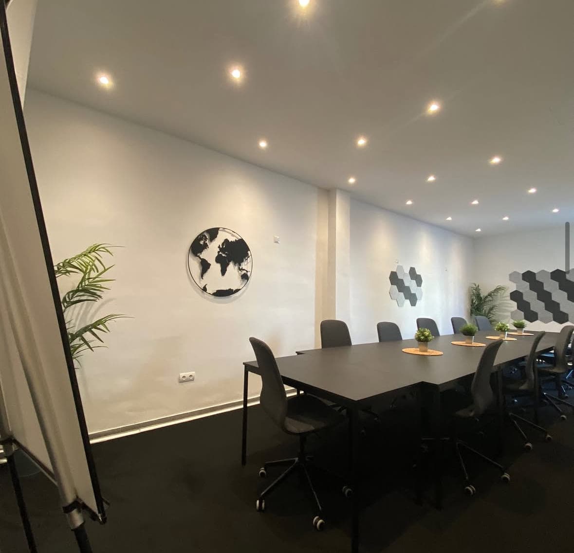 Lange Seminartafel mit Bürostühlen und Akustikpaneelen an der Wand
